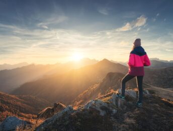 Donna che osserva un tramonto in montagna
